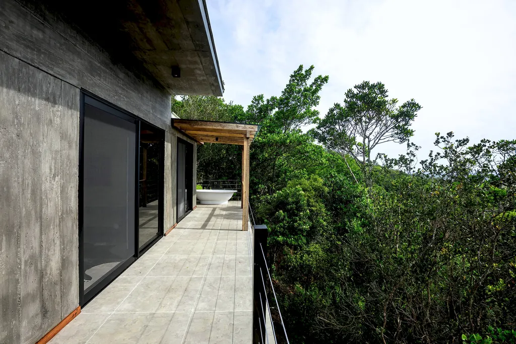 Corredor do deck do Espaço Bosque levando à banheira externa entre as árvores
