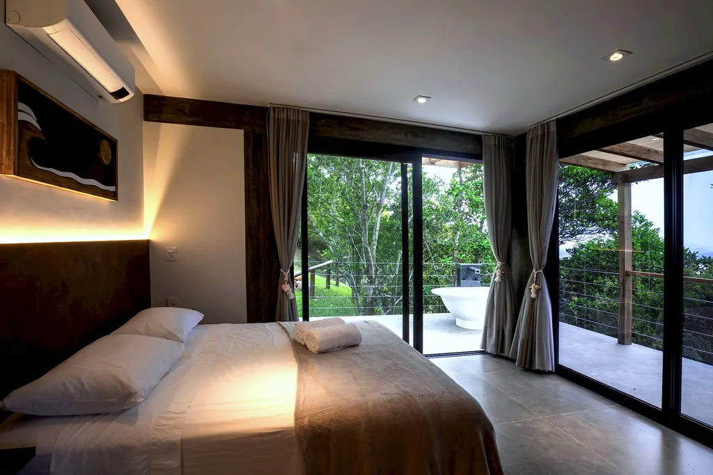 Quarto do Espaço Bosque com cama de casal e vista para o deck