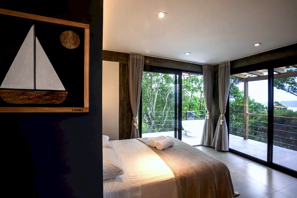 Quarto do Espaço Bosque com quadro de veleiro e portas de vidro