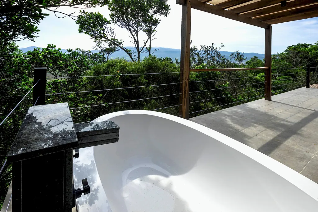 Banheira de imersão no deck com vista para a mata e as montanhas