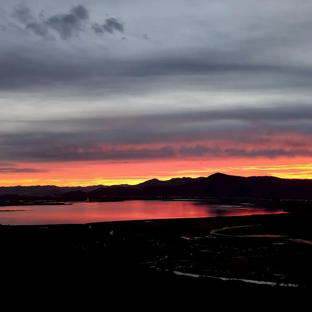 Pôr do sol sobre a lagoa e a serra vistos do Refúgio da Silveira, em Garopaba