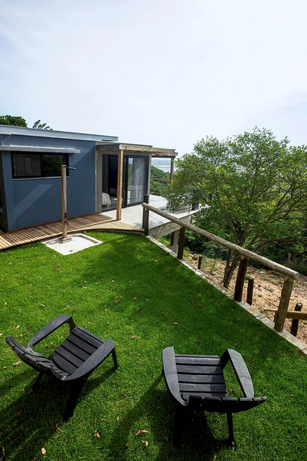 Casa do Espaço Lagoa com gramado, chuveiro externo e árvores nativas